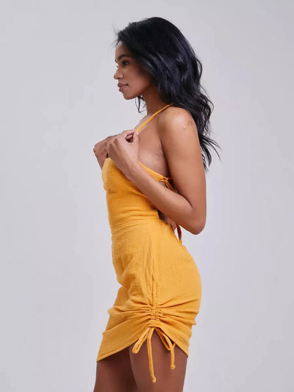Model showcasing the Citrus Rush summer dress in vibrant yellow, featuring a flattering bodycon fit and adjustable crisscross back.