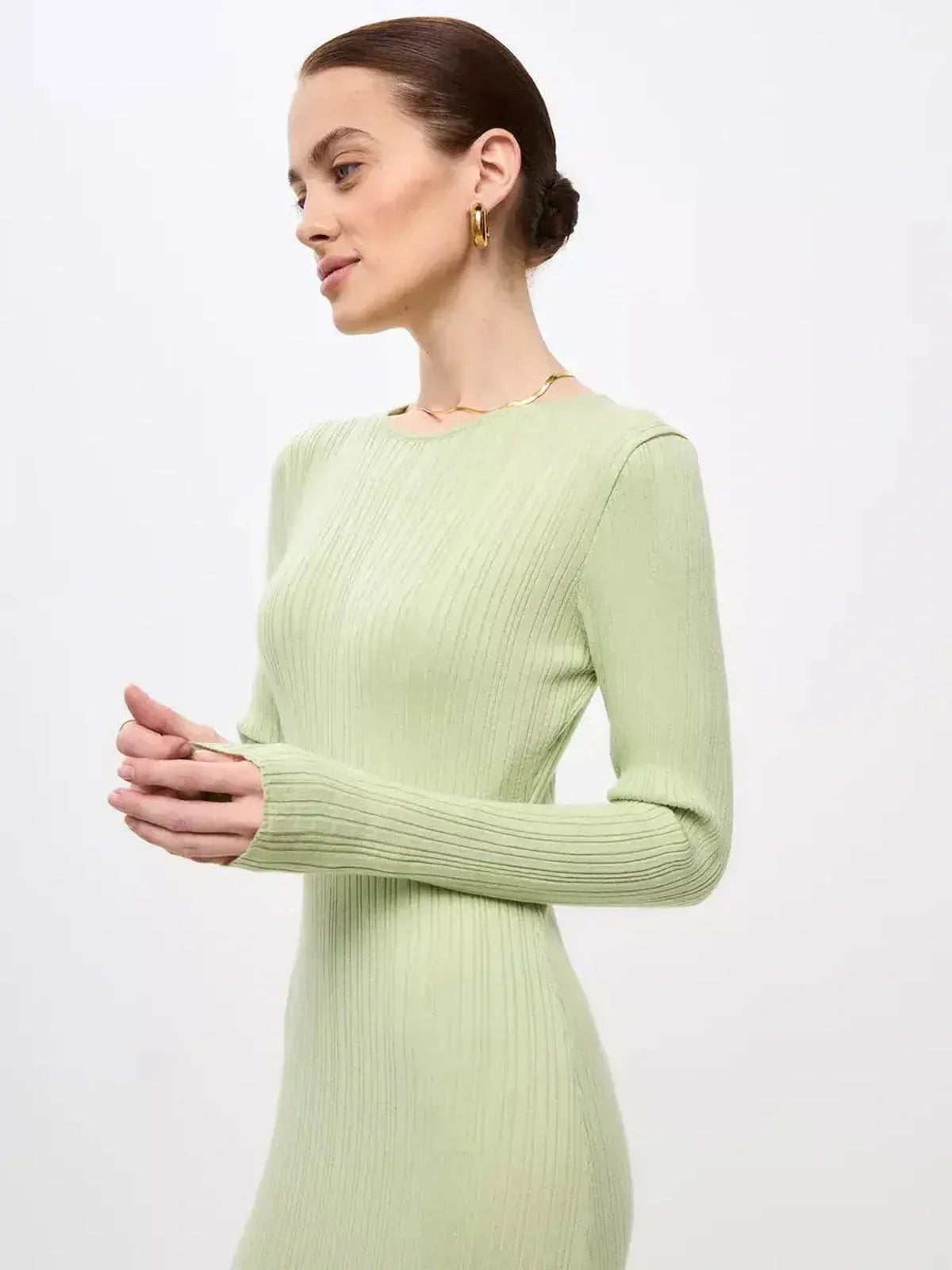 Model showcasing the Celery Luxe Maxi Dress, a light green ribbed knit dress with long sleeves and a sculpted fit.