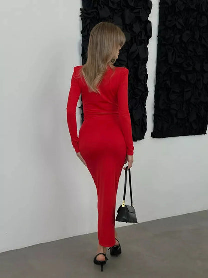 Model wearing a Sculpted Glam Maxi Dress in red, showcasing a sleek fit and long sleeves, perfect for elegant occasions.