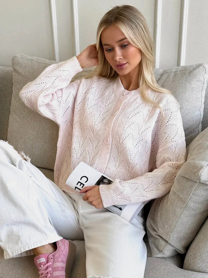 Model wearing a Blush Cardigan by Lauven, featuring soft pink knit and lace pattern, styled with casual white jeans.