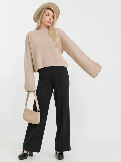 Siena Sweater by Lauven in beige knitwear, featuring relaxed fit and paired with stylish black pants.