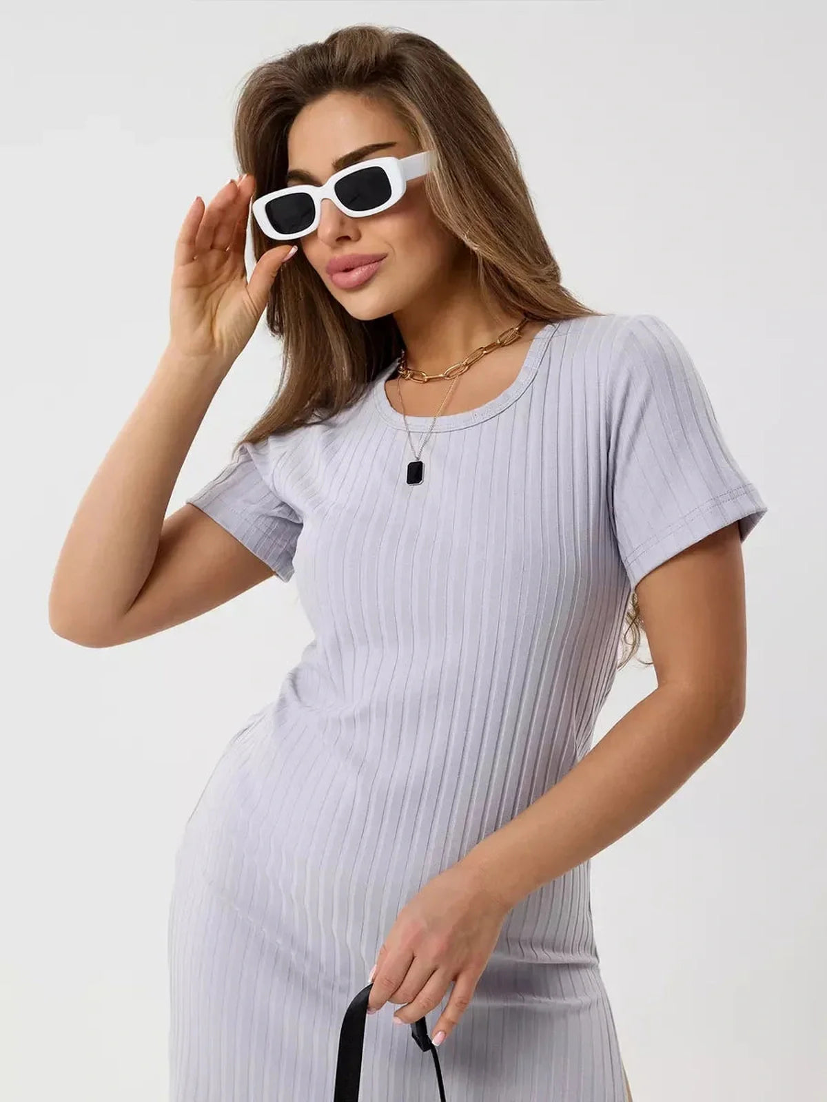 Model wearing a light ribbed Cloudline Mini dress with sunglasses, showcasing summer style and elegance.