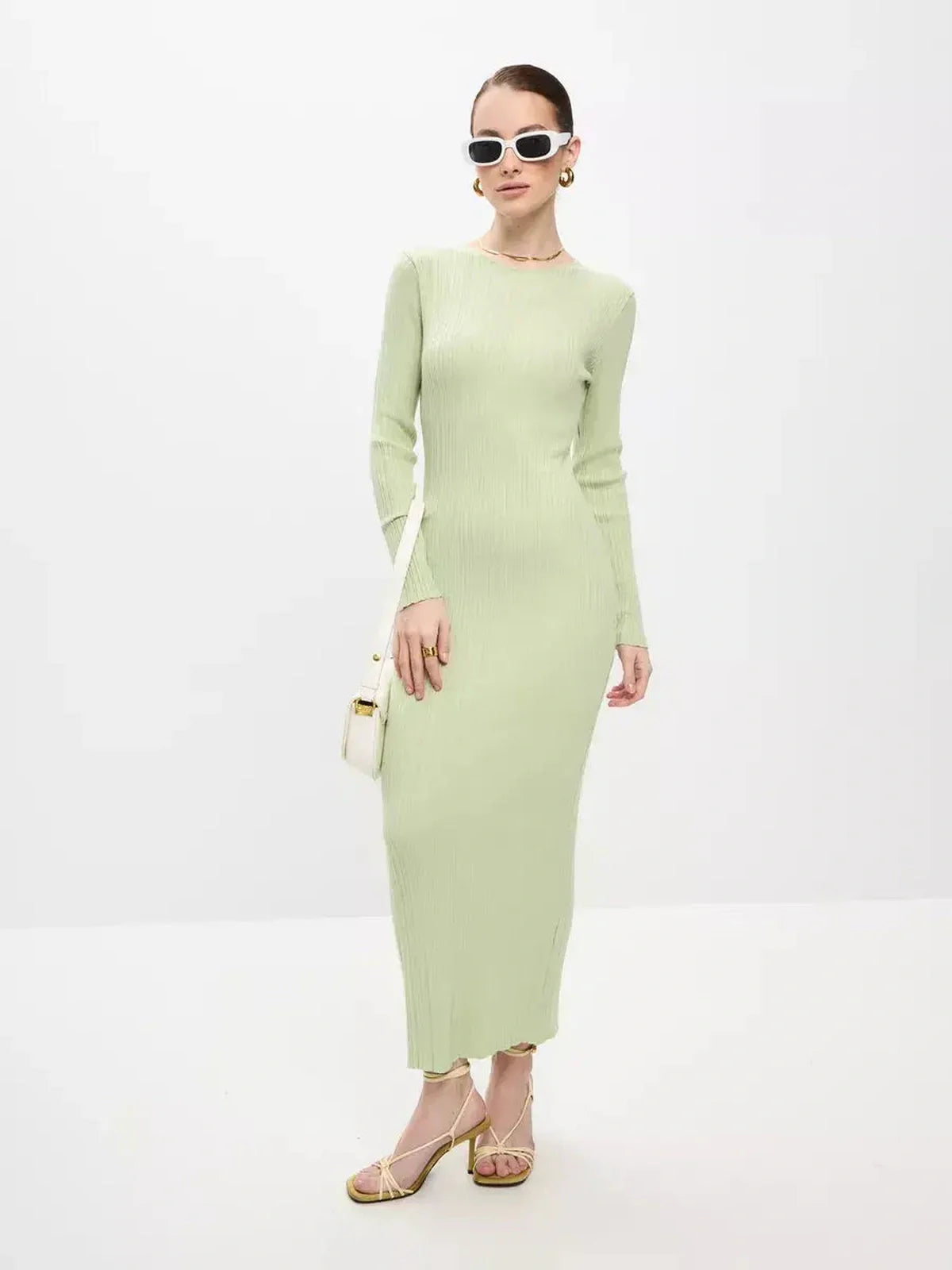 Model wearing a light green ribbed Celery Luxe Maxi Dress, showcasing seamless elegance and sculpted fit with stylish accessories.