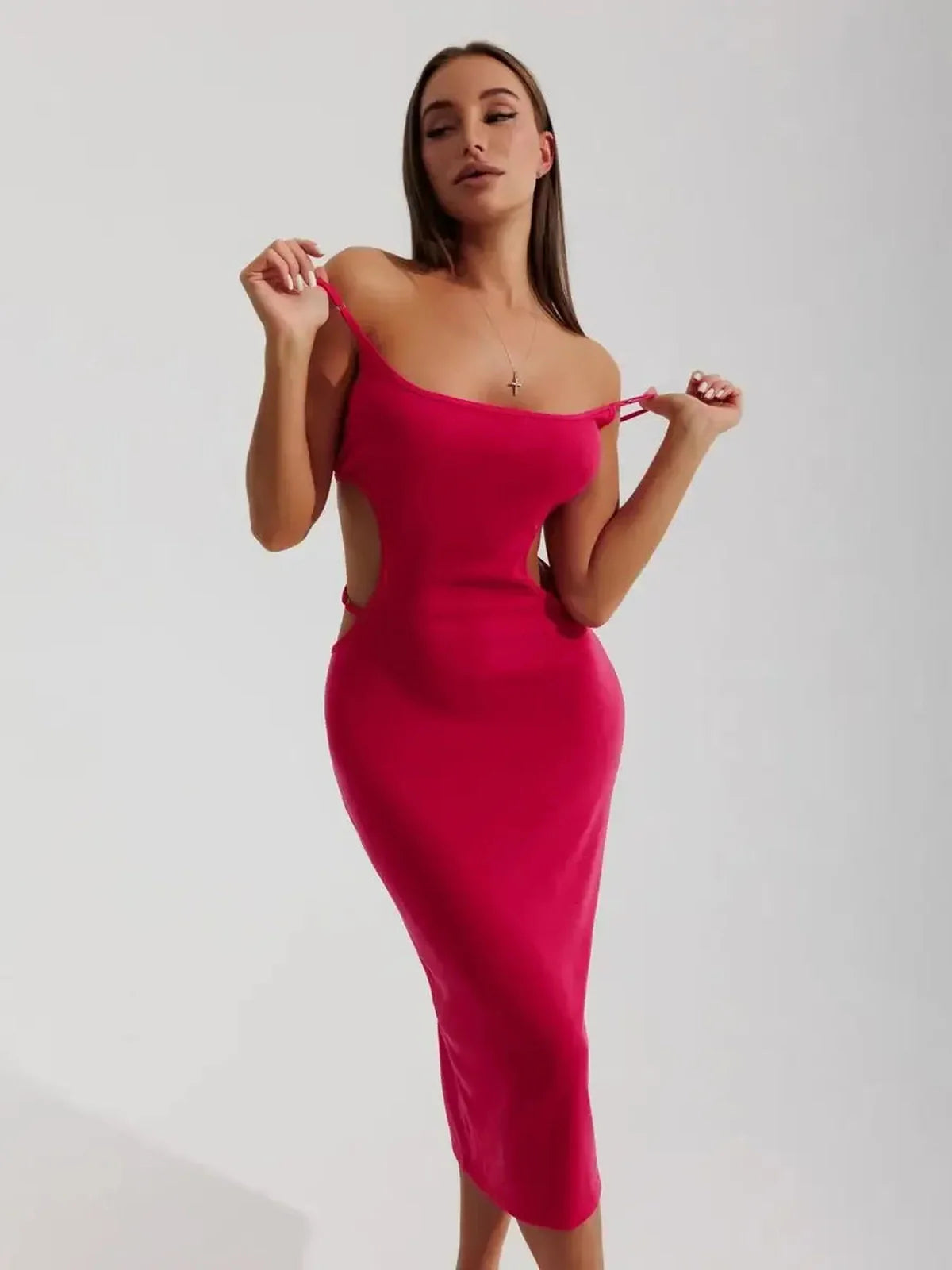 Model showcasing the Sculpt Midi Dress in bold pink, featuring contour cutouts and a figure-hugging midi silhouette.