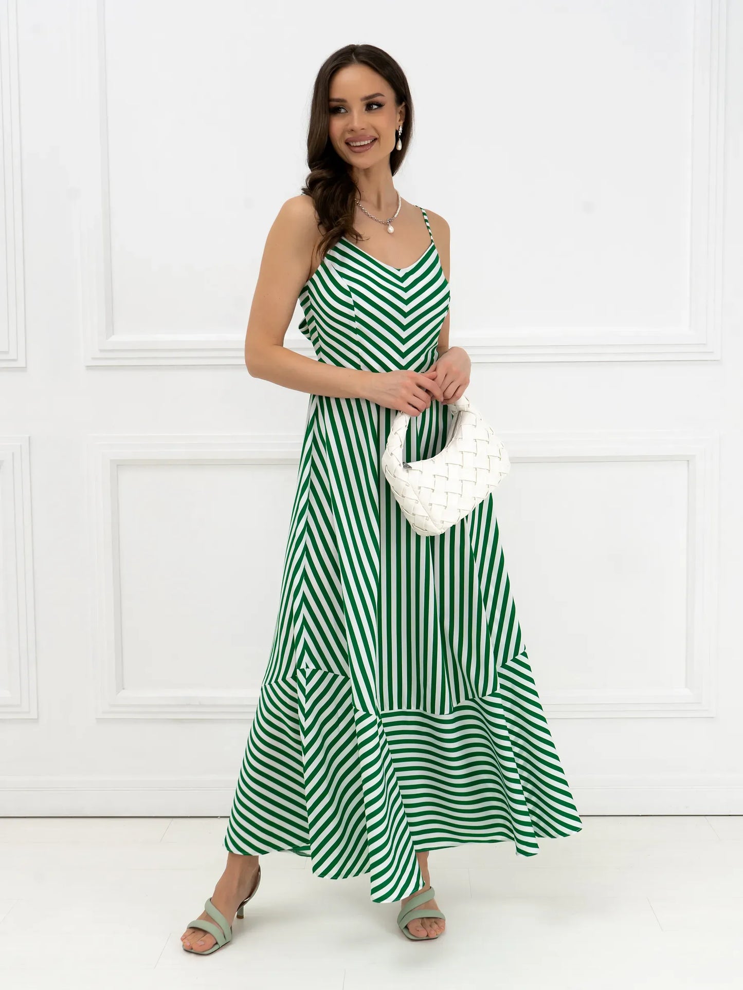 Model wearing Verde Vibe Maxi Dress, featuring green and white stripes with back bow detail for effortless summer style.