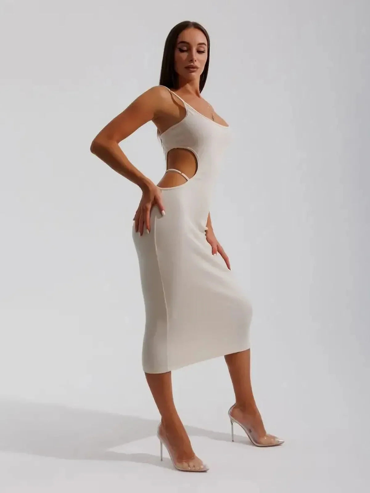 Model showcasing Midi Dress Seraphine, a beige ribbed knit dress with elegant side cutouts and bodycon fit.