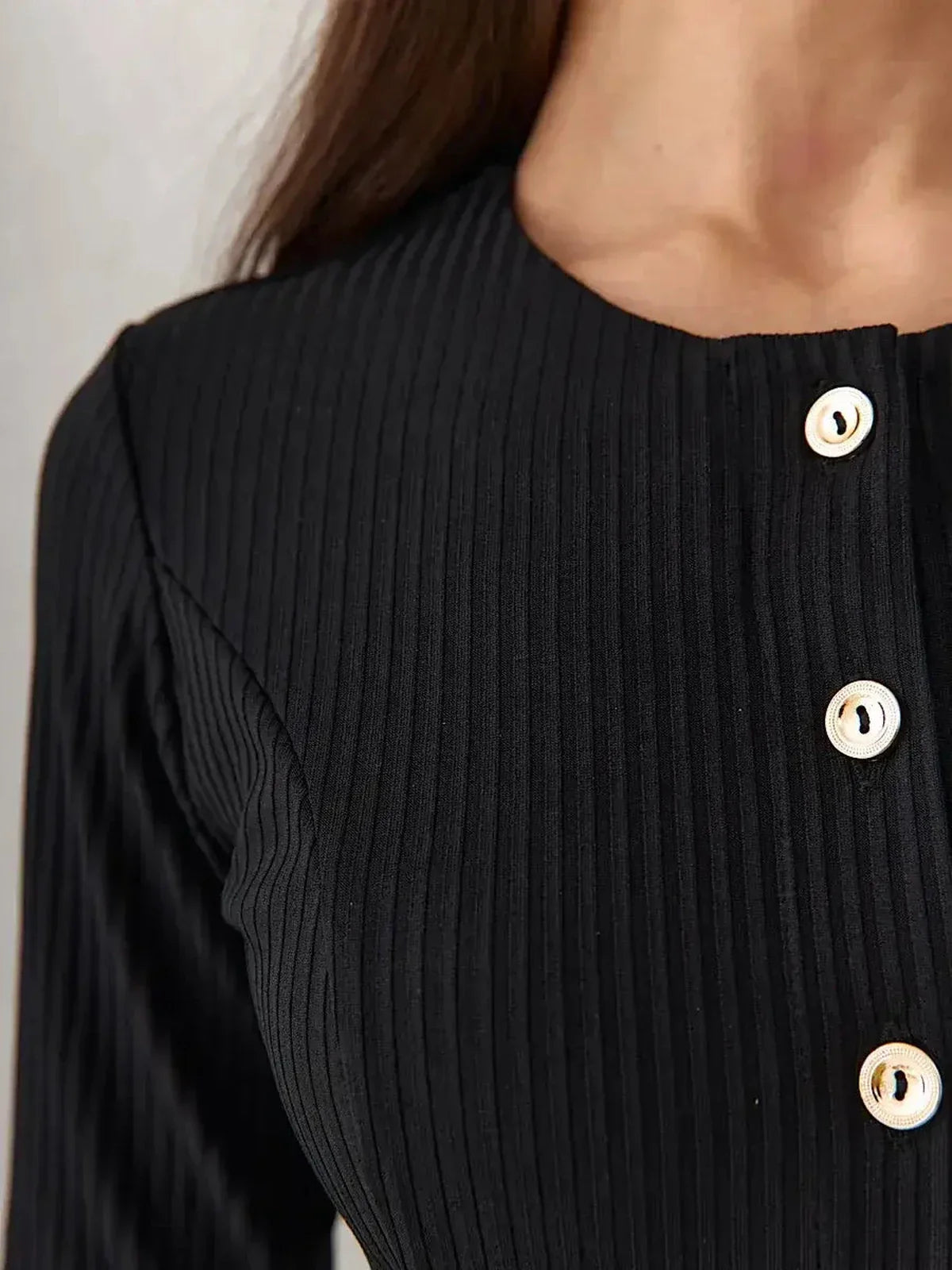 Close-up of the Serene Grace Midi Dress showcasing the luxurious black ribbed texture and decorative buttons.