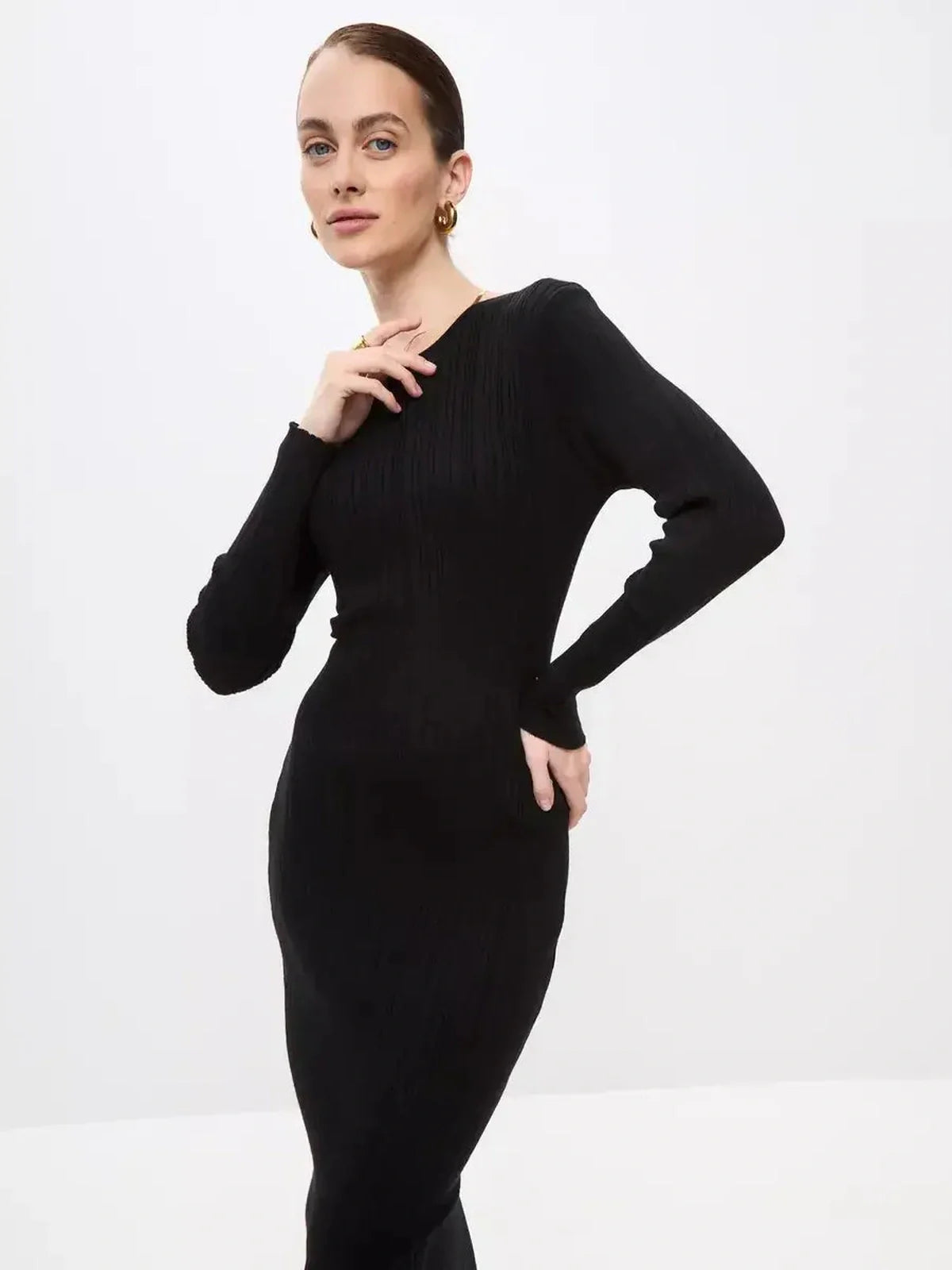 Model showcasing a Sculpted Rib Maxi Dress in black, featuring long sleeves and a flattering body-skimming fit.