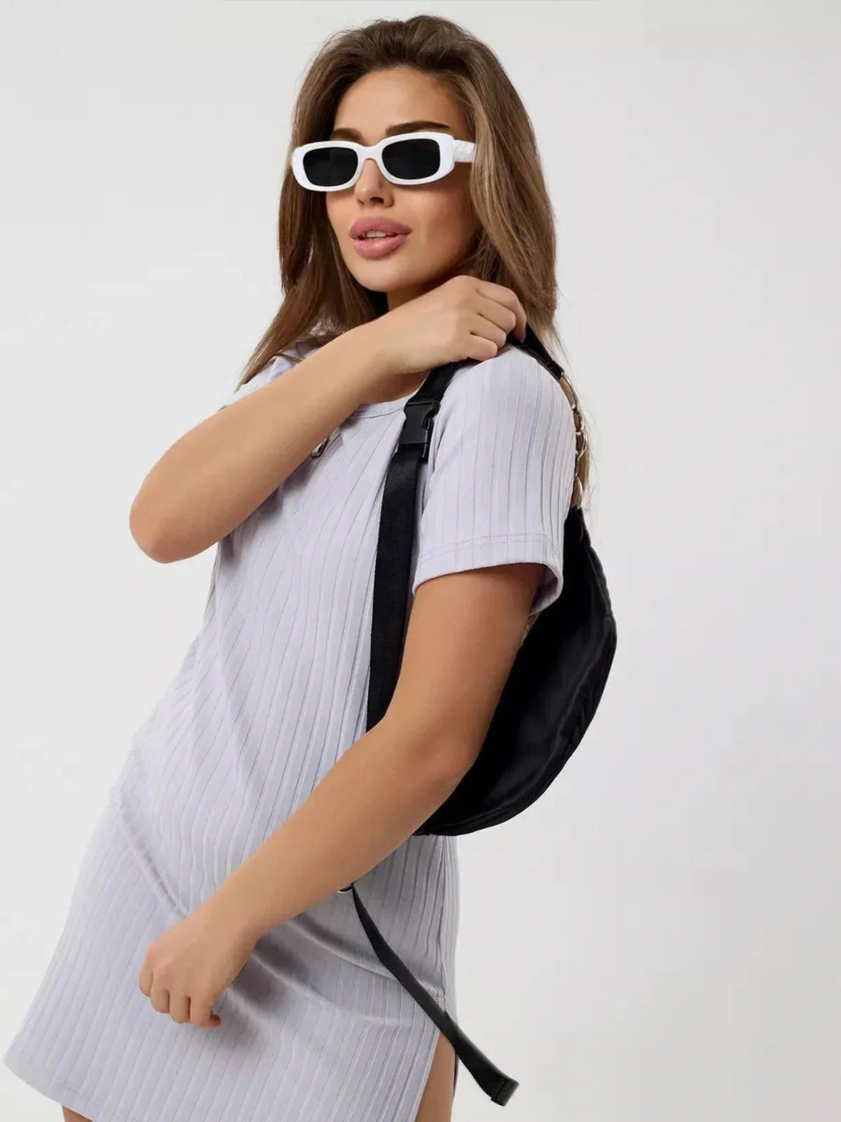 Model wearing Cloudline Mini ribbed summer dress with a black backpack and sunglasses, showcasing casual elegance.