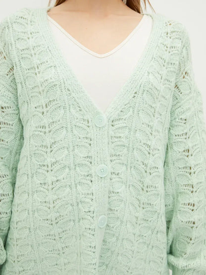 Celestia Cardigan by Lauven in soft green, featuring a delicate jacquard knit pattern and V-neckline.