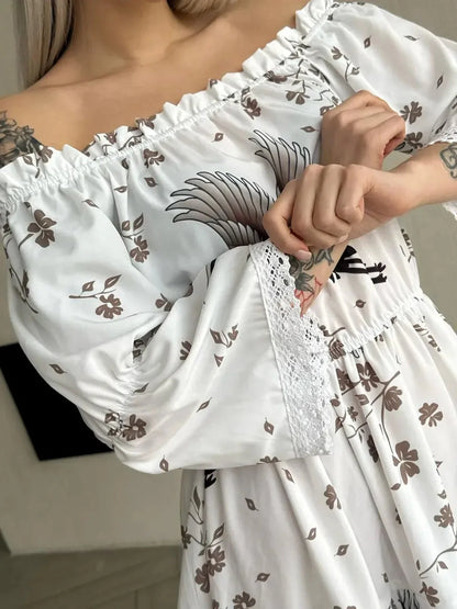 Close-up of a woman wearing a white crane summer dress with floral patterns and off-shoulder design.