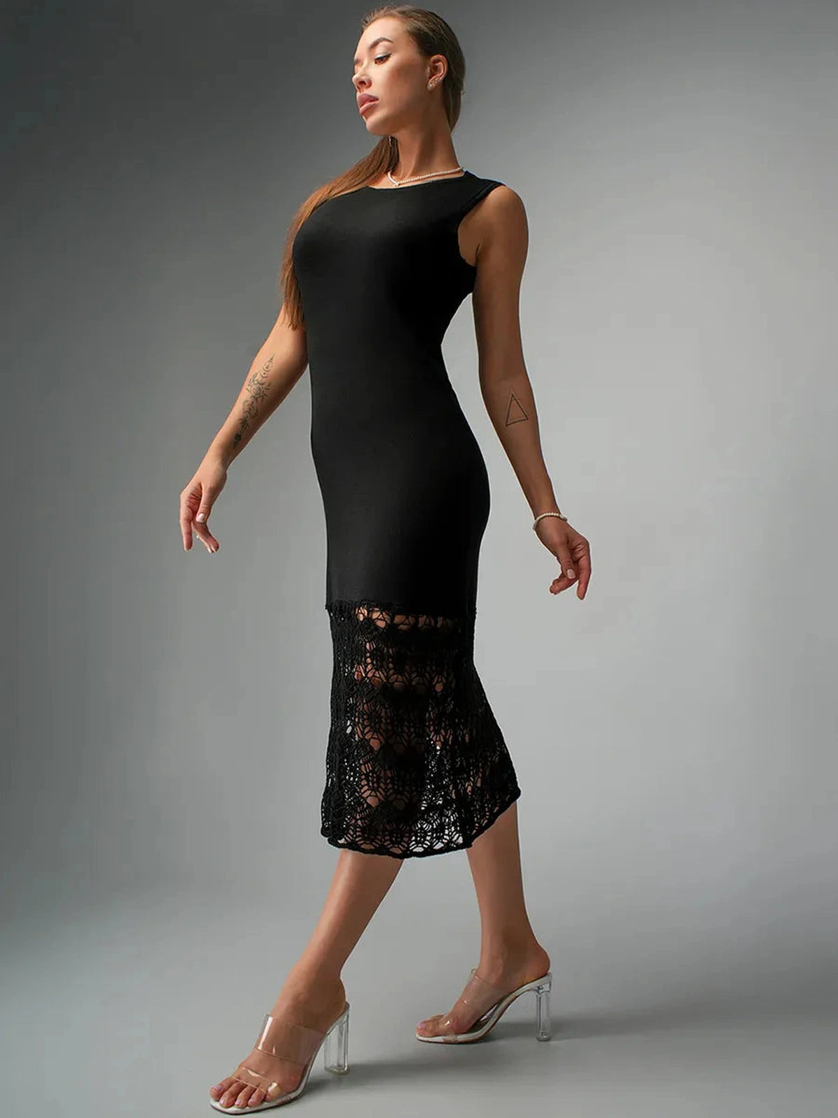 Elegant model showcasing Velora Midi Dress by Lauven, featuring black knit fabric and delicate crochet detailing.