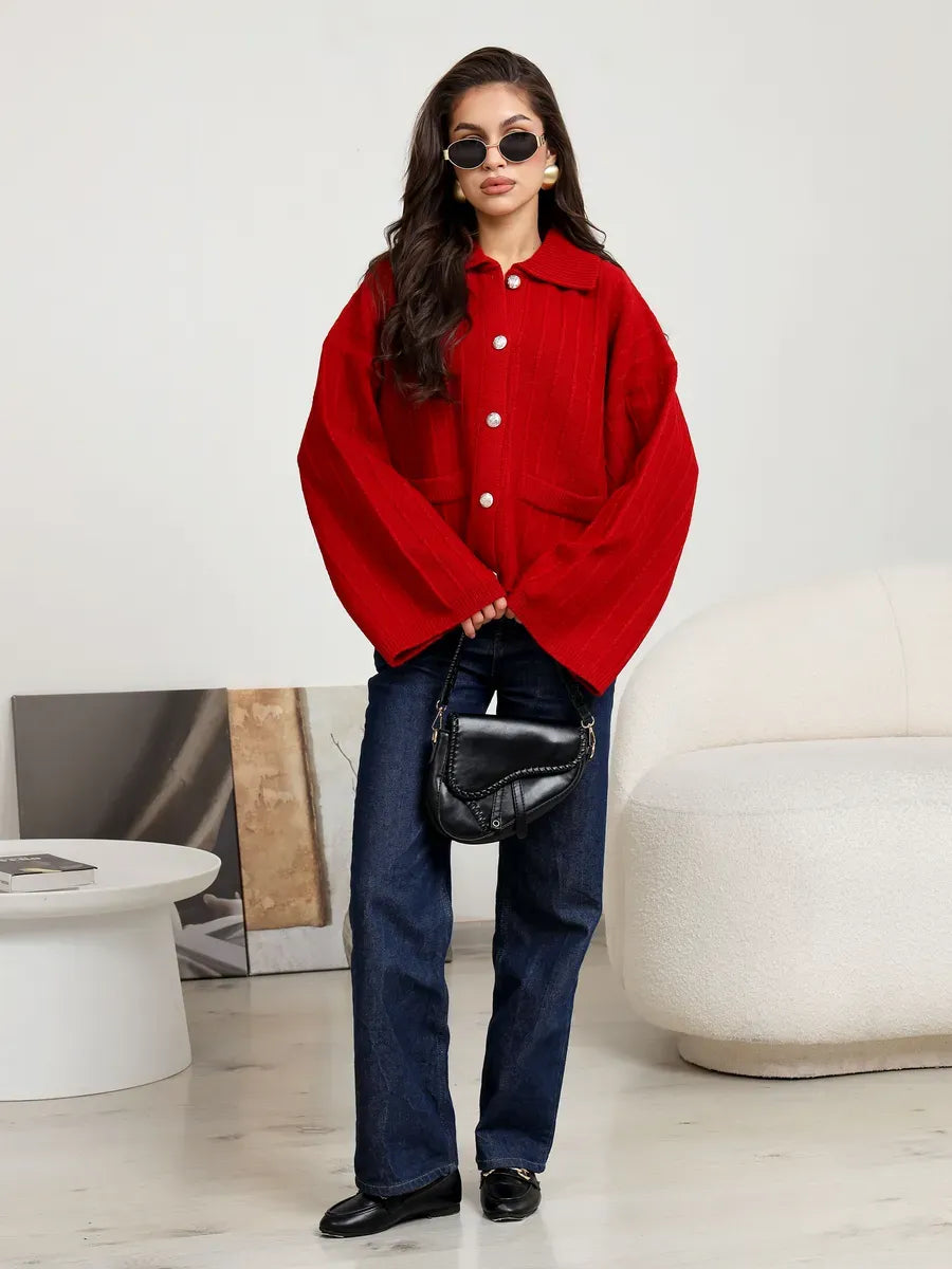 Model wearing a Crimson Cardigan by Lauven, a bold red oversized knit with wide sleeves and stylish flair.