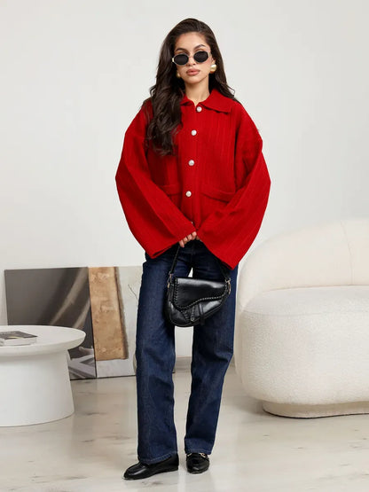Model wearing a Crimson Cardigan by Lauven, a bold red oversized knit with wide sleeves and stylish flair.