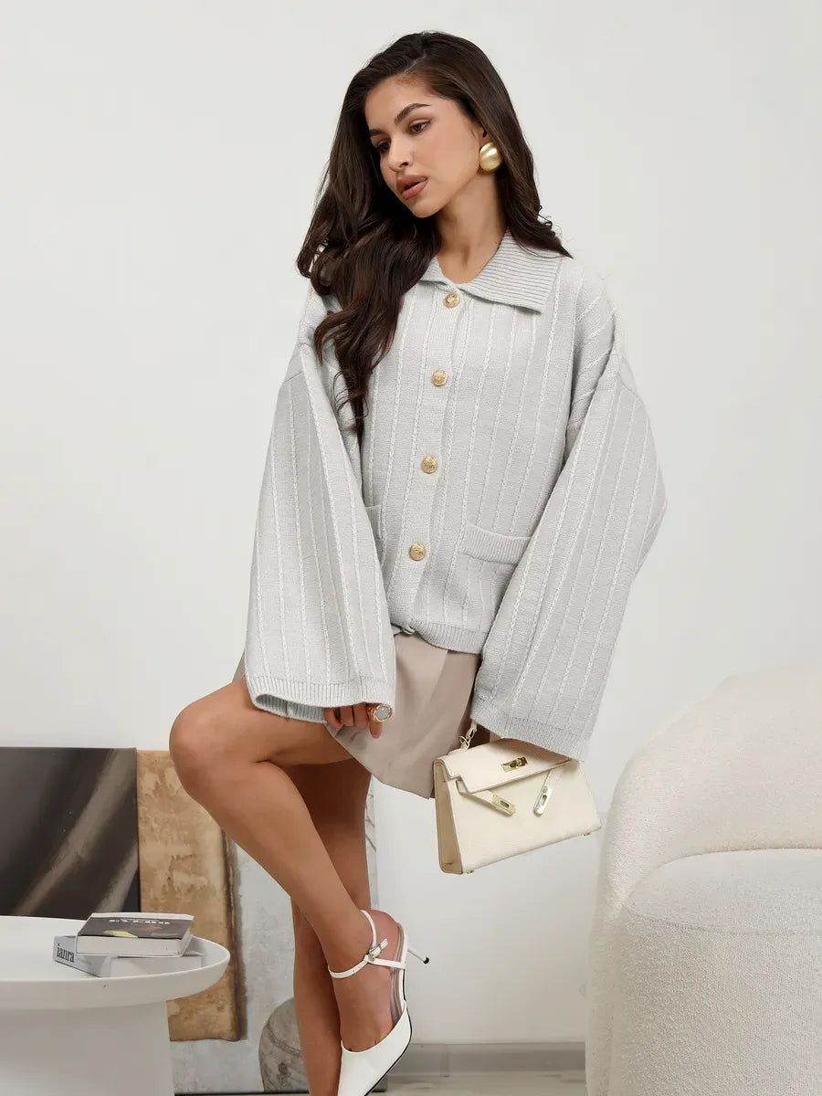 Chic model showcasing the Glacier Cardigan by Lauven in light gray oversized knitwear with bell sleeves.