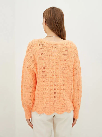 Elysia Cardigan by Lauven in coral, showcasing soft jacquard knit from the back, perfect for stylish comfort.