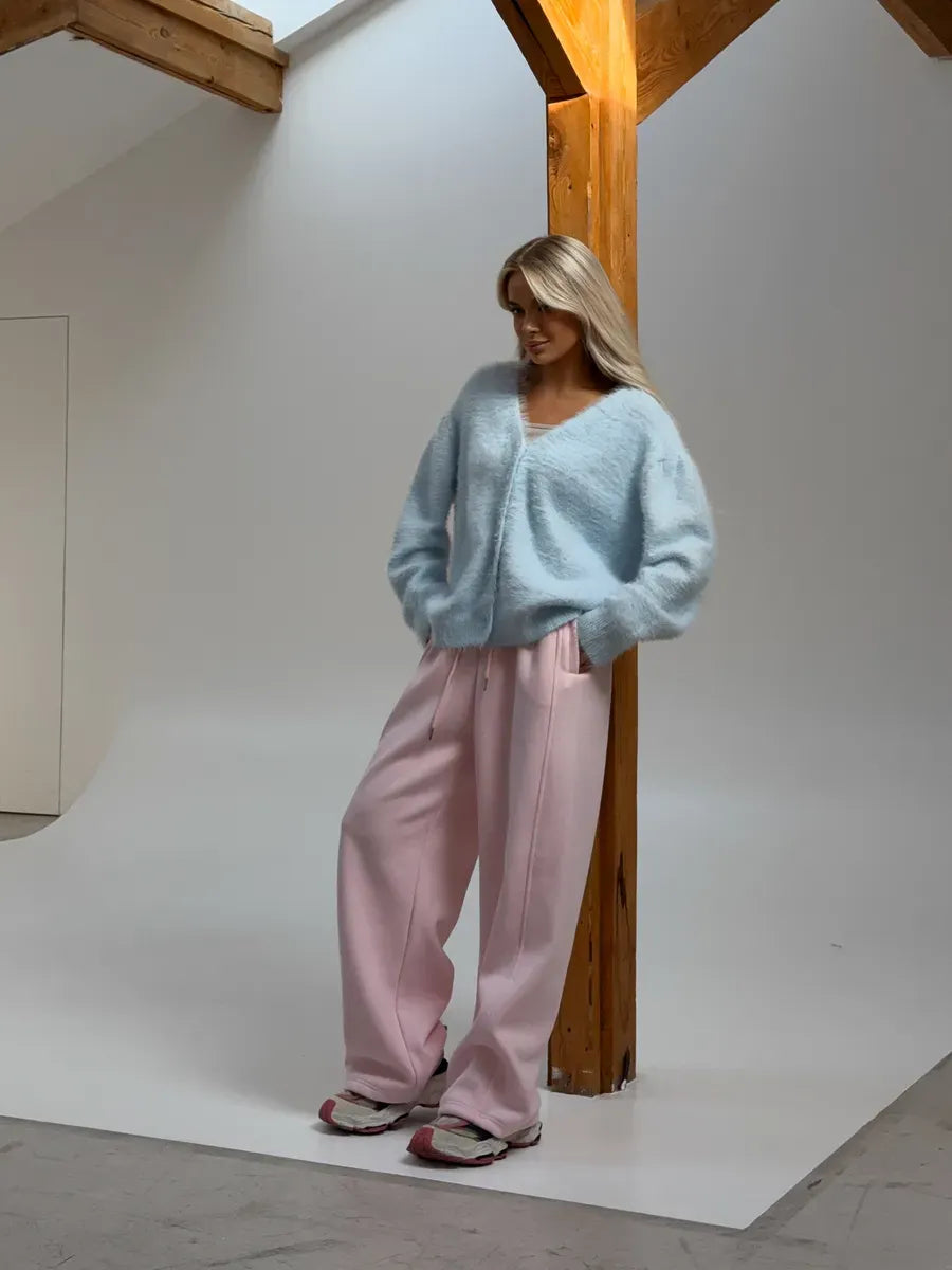 Model wearing an Azure Cardigan by Lauven, oversized light blue fluffy knit paired with pink trousers.