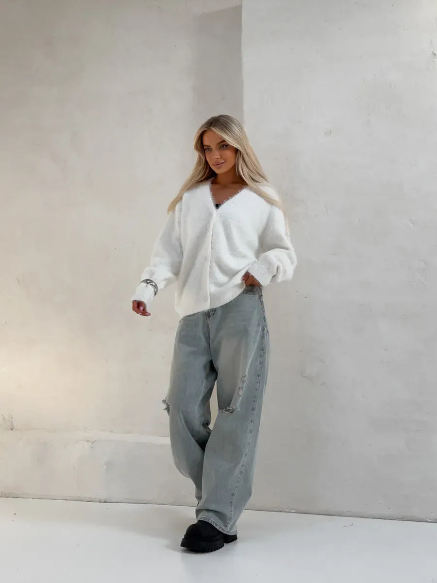 Model wearing the Luna Cardigan by Lauven, an oversized white fluffy knit cardigan with button closure.