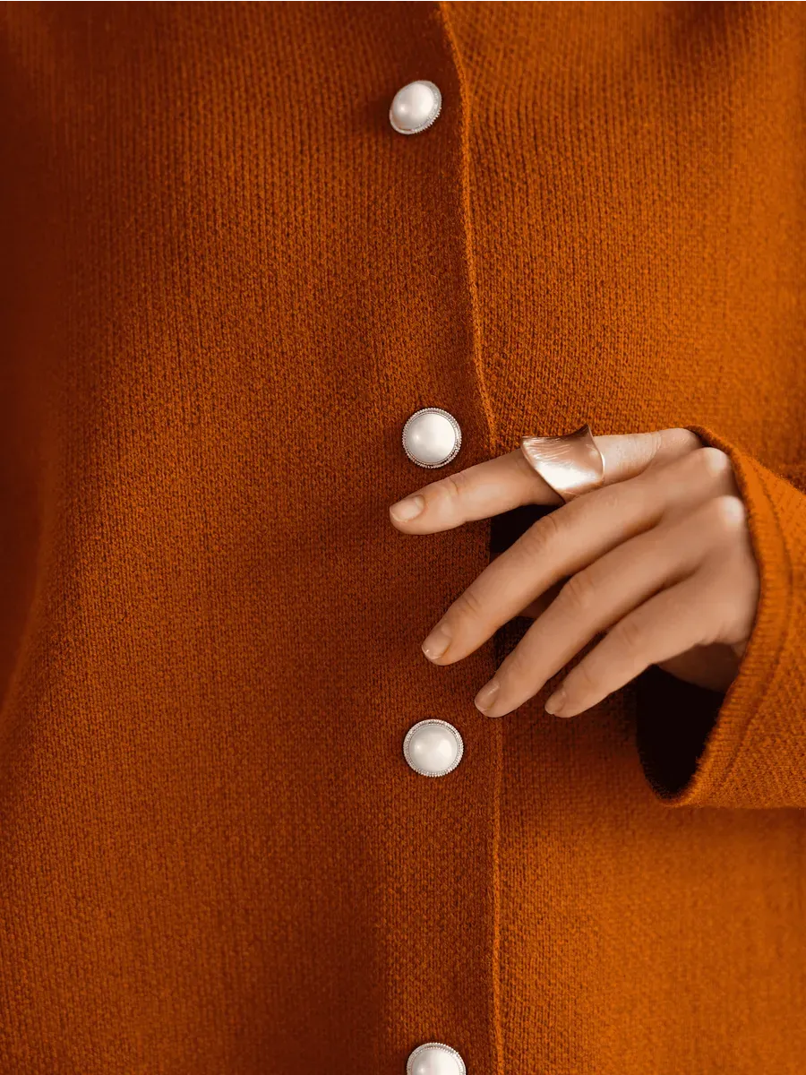 Tangelo Cardigan by Lauven, featuring warm orange knitwear with button closure and stylish ring accessory.