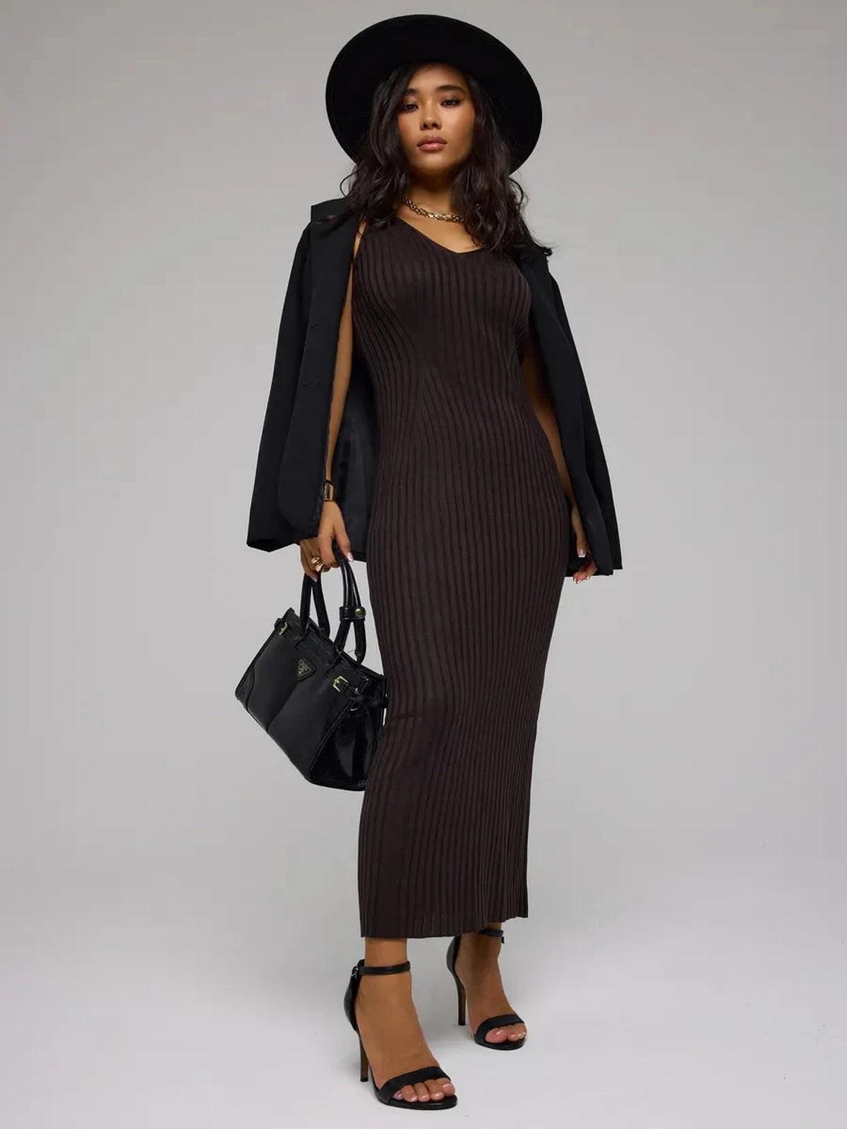 Model wearing Cacao Maxi Dress by Lauven, a chic brown ribbed knit dress, showcasing a stylish look with accessories.