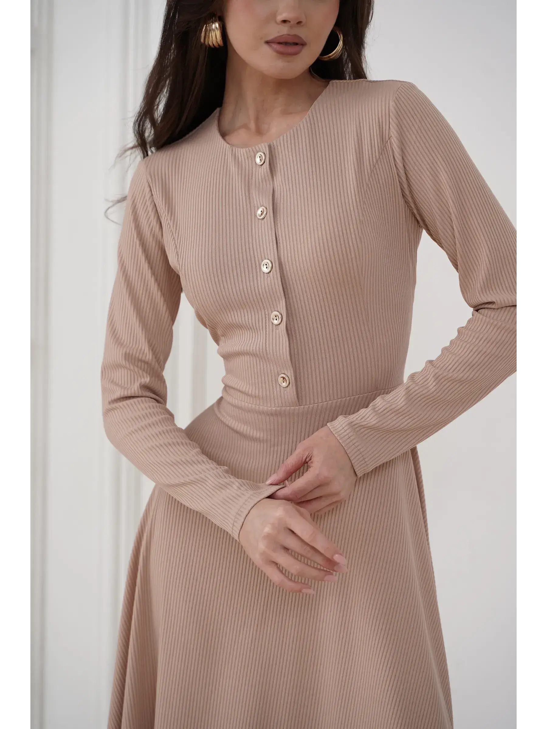 Close-up of the Sculpted Ease Midi Dress in beige, featuring ribbed knit fabric and gold-tone buttons for elegant style.