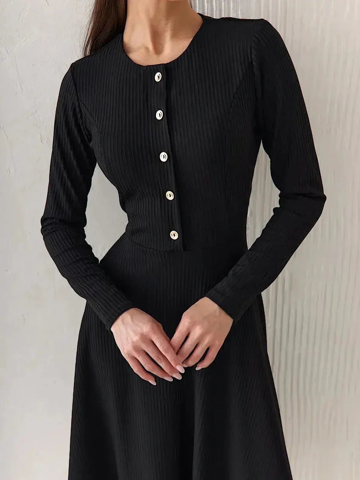 Elegant black ribbed midi dress with decorative buttons and tailored fit, perfect for office or evening wear.