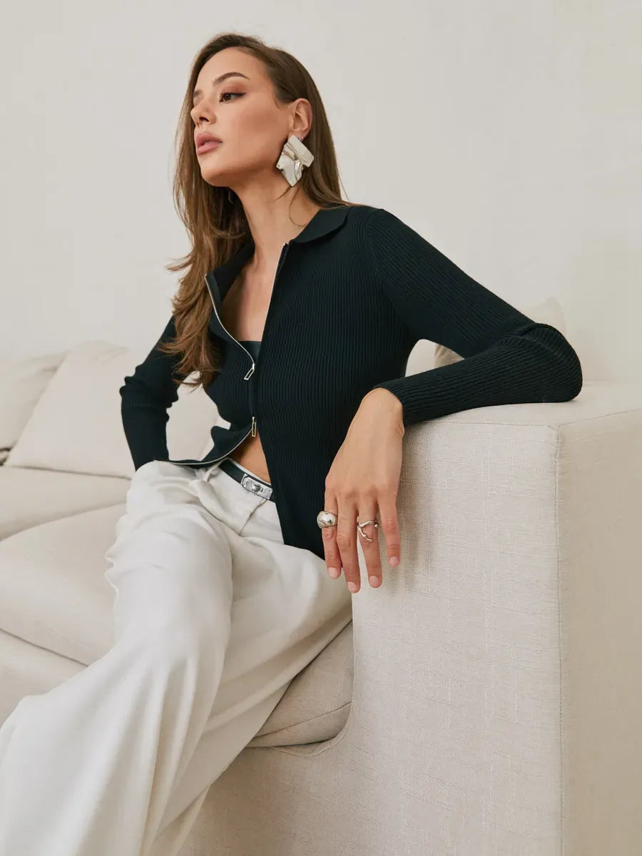 Elegant woman wearing a Nova Cardigan in black ribbed knit with two-way zipper, styled with chic accessories.