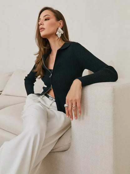 Elegant woman wearing a Nova Cardigan in black ribbed knit with two-way zipper, styled with chic accessories.