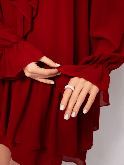 Close-up of hands showcasing ruffle detailing of the Marsella Mini Dress in luxurious wine-red by Lauven.