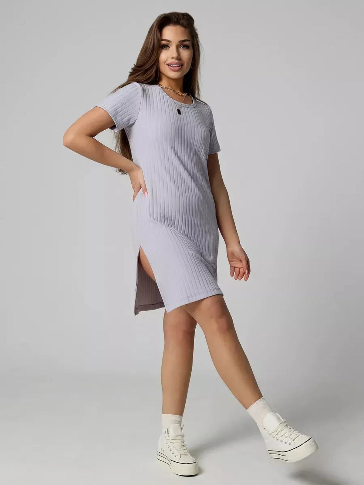 Model wearing the Cloudline Mini ribbed summer dress in light purple, showcasing short sleeves and side slit.