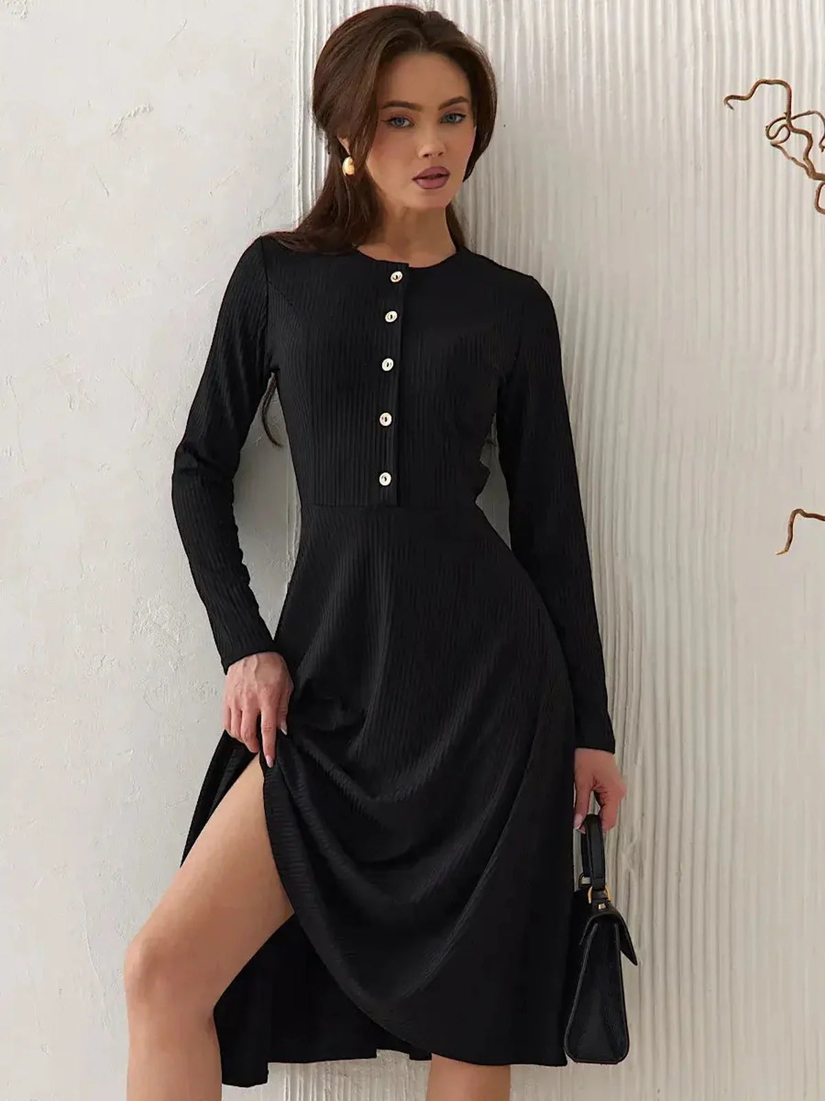 Elegant black ribbed midi dress with decorative buttons and a flared skirt for a sophisticated look.