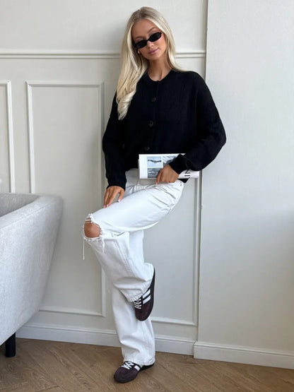 Onyx Cardigan by Lauven – Elegant button-up knit in soft textured fabric, styled with white jeans and black sunglasses.