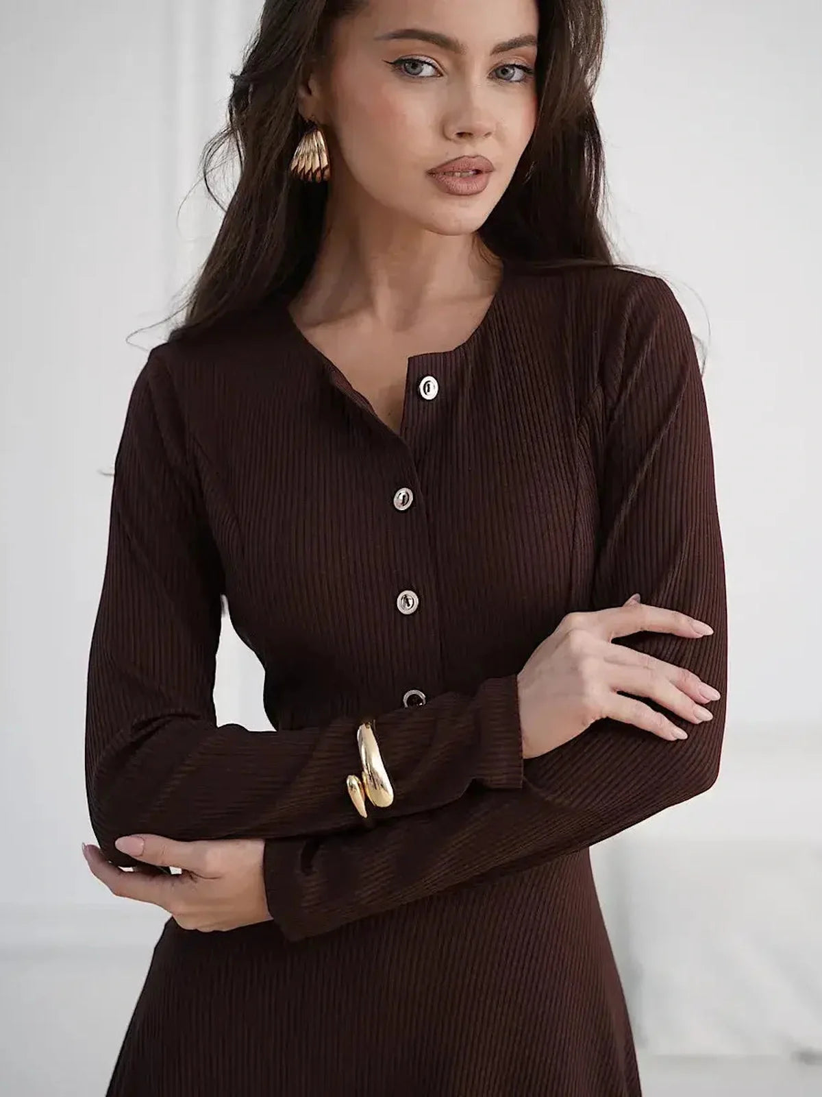 Model wearing the Midi Dress Noirette, showcasing its button detailing and flattering silhouette in a rich brown shade.