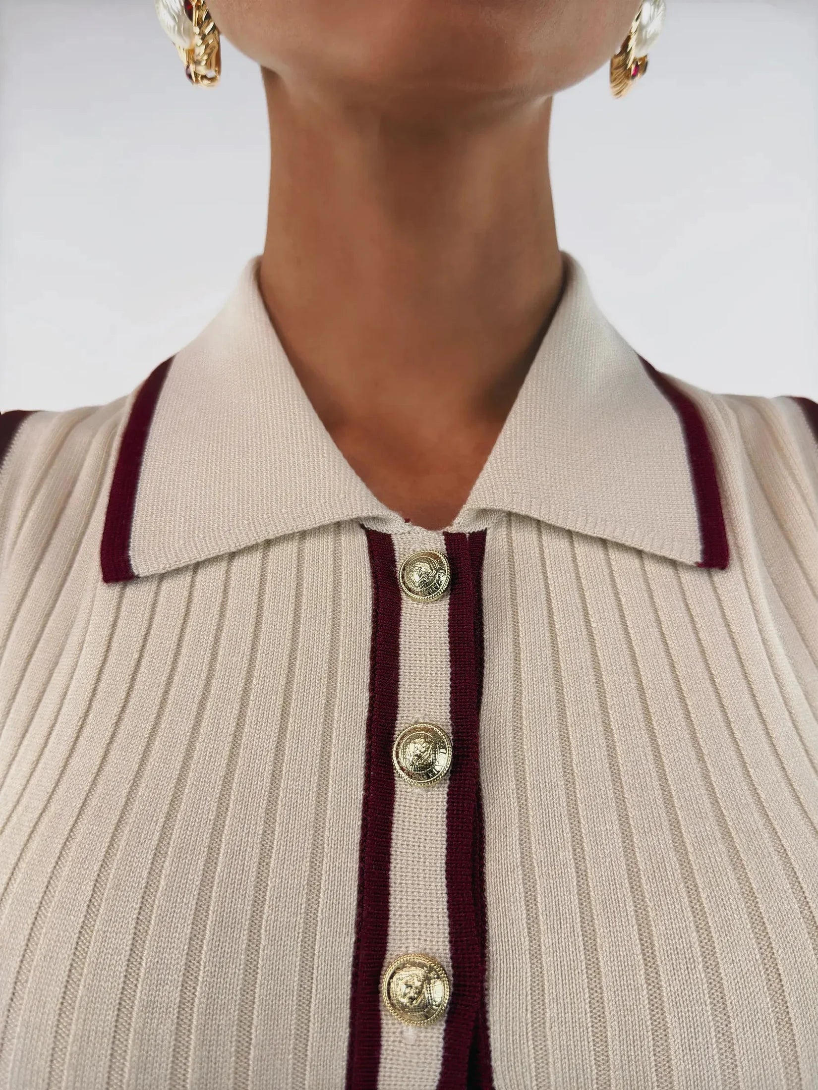 Close-up of Serena Midi Dress collar showing cream ribbed knit fabric and burgundy trim with gold-tone buttons.