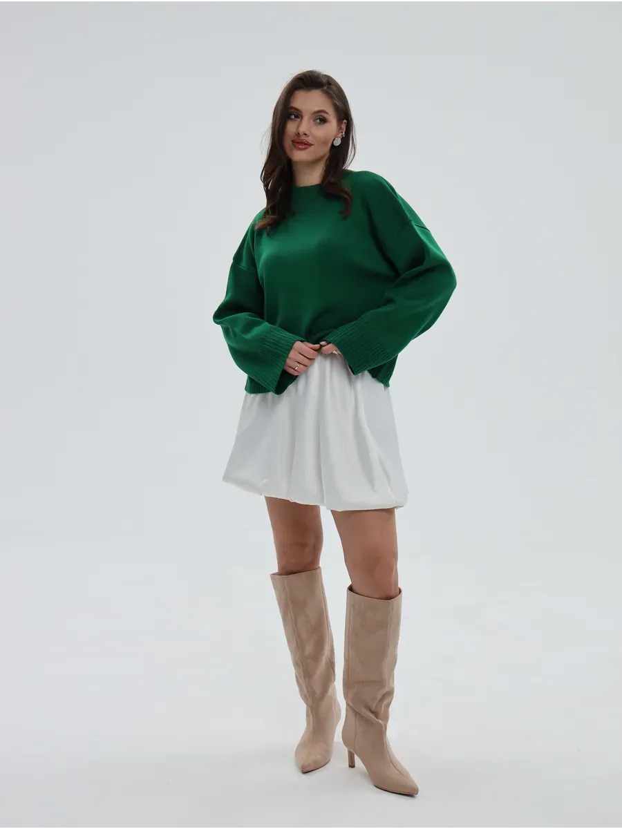 Emerald Sweater by Lauven, oversized knitwear in rich green, styled with a white skirt and beige boots.