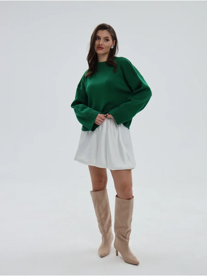 Emerald Sweater by Lauven, oversized knitwear in rich green, styled with a white skirt and beige boots.