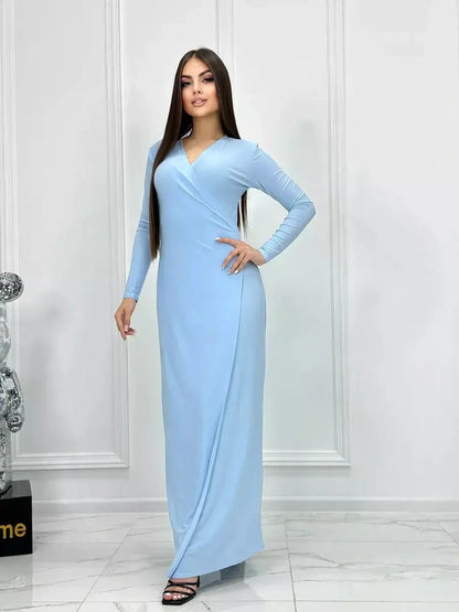 Celeste Charm Maxi Dress in light blue, featuring long sleeves and a flattering wrap silhouette for versatile styling.