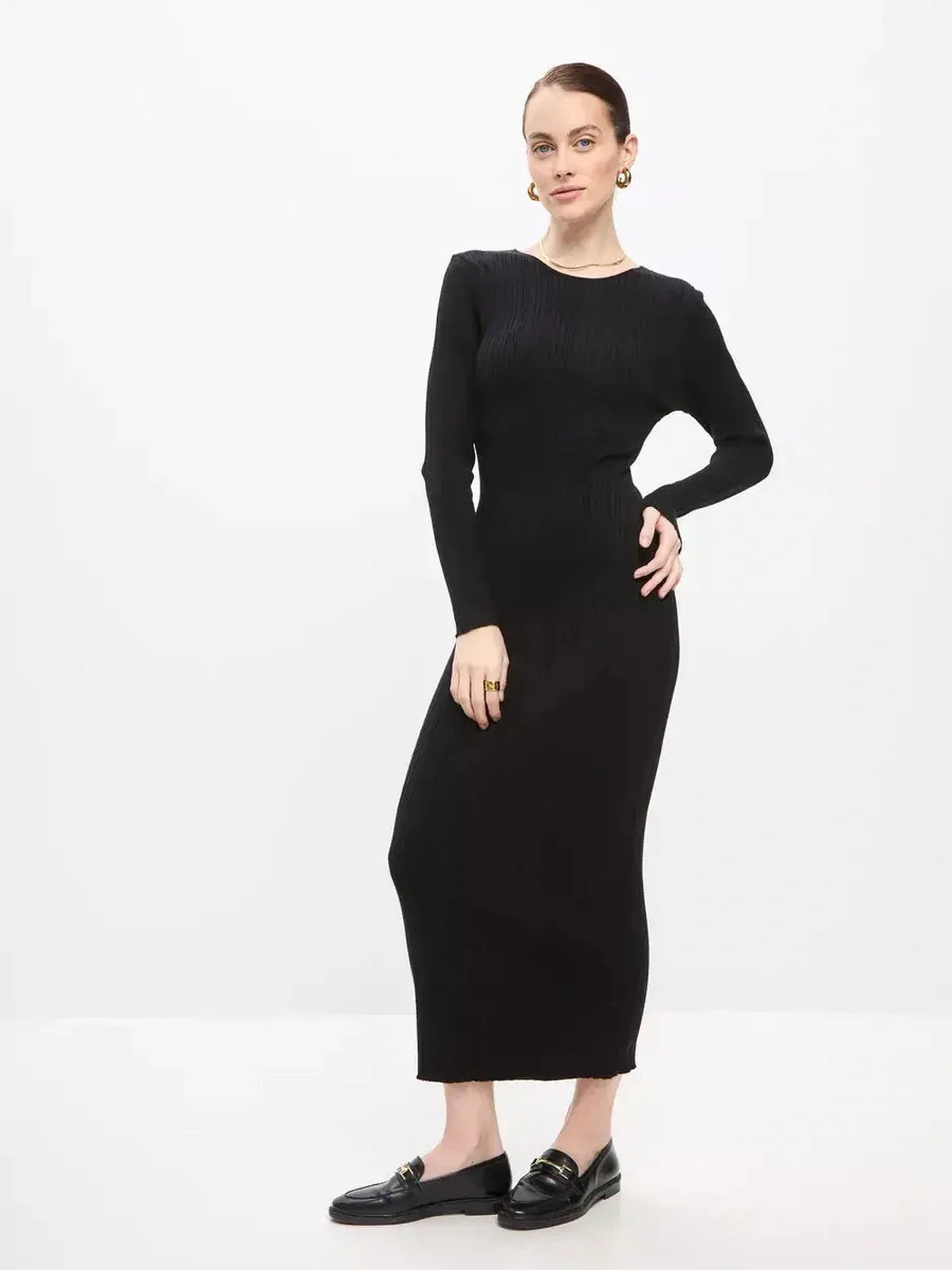 Model wearing a black Sculpted Rib Maxi Dress with long sleeves, showcasing a streamlined silhouette and ribbed texture.