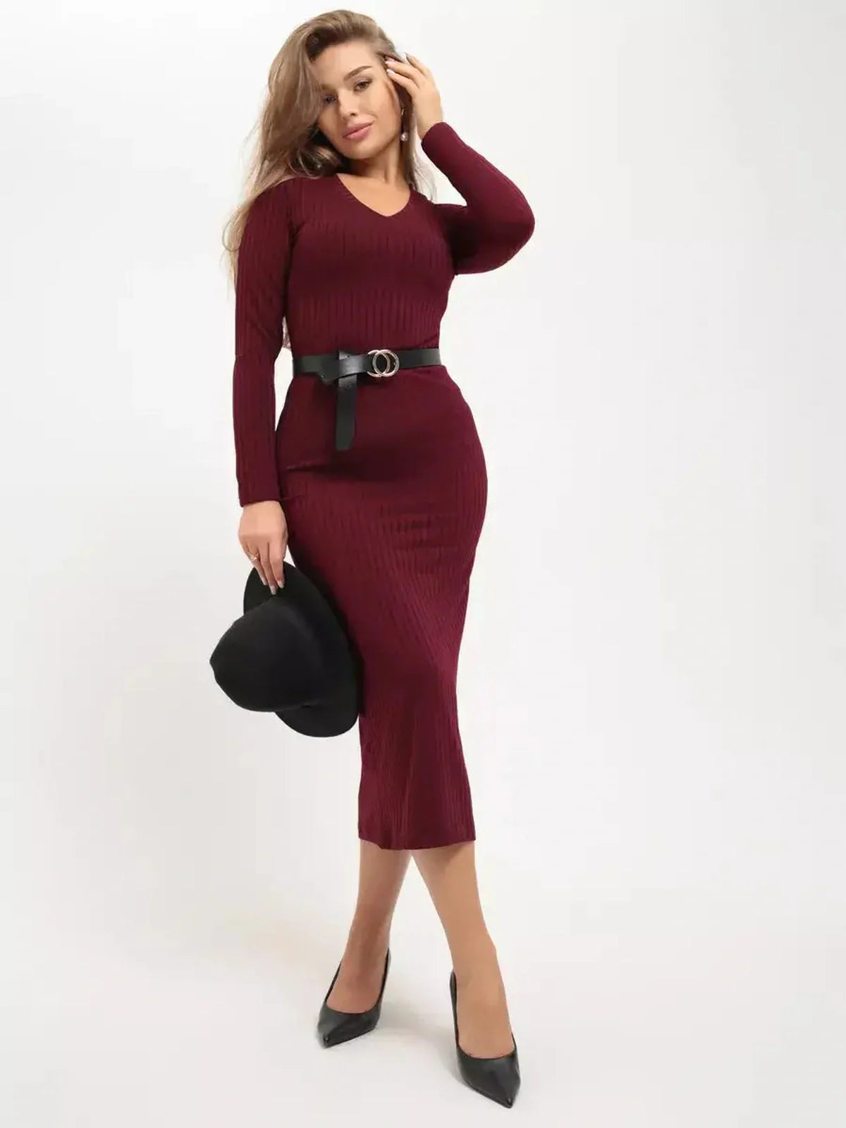 Model wearing a burgundy ribbed midi dress, styled with a belt and a black hat, exuding elegance and sophistication.