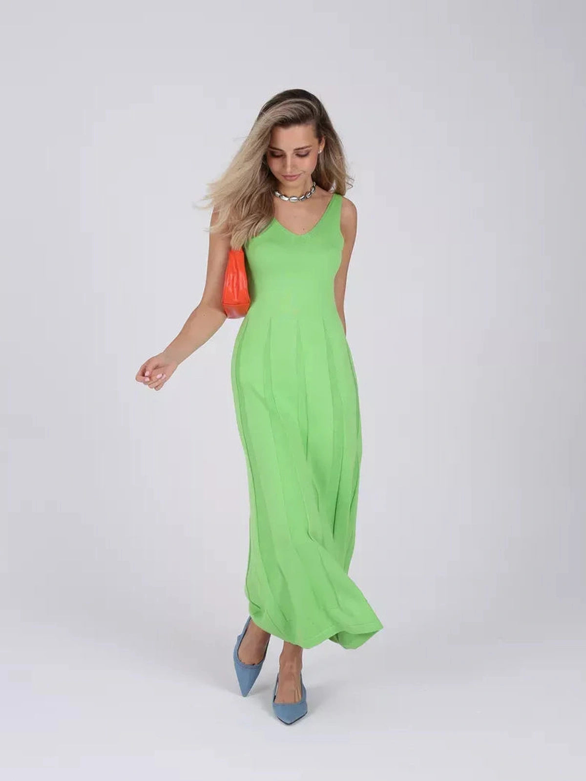 A woman wearing a Verde Maxi Dress in vibrant green, showcasing elegance and style by Lauven.