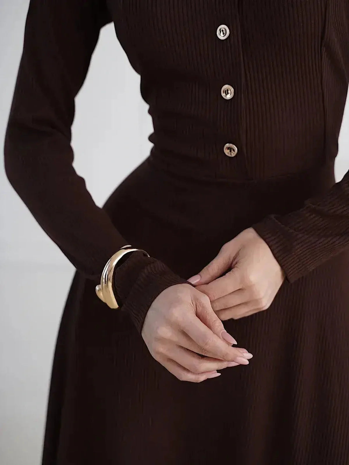 Elegant brown midi dress featuring button detailing and a flattering fit-and-flare silhouette.