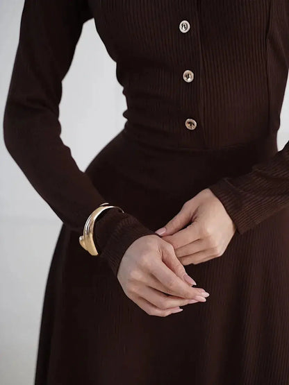 Elegant brown midi dress featuring button detailing and a flattering fit-and-flare silhouette.