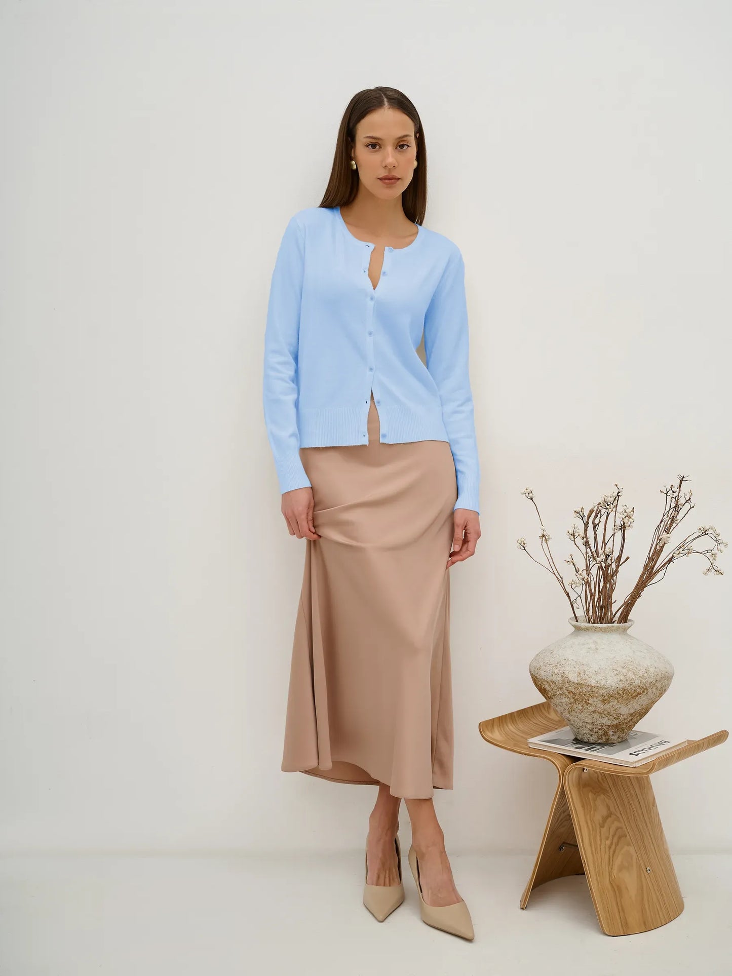 Celeste Cardigan by Lauven, lightweight blue knitwear with button closure, styled with a beige skirt.