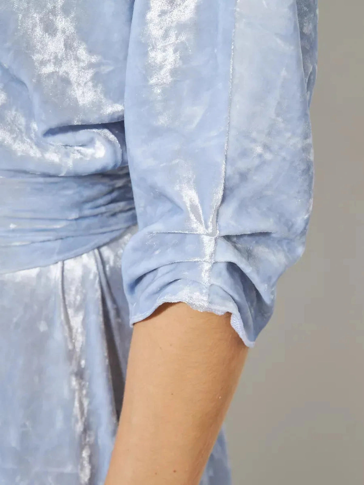 Close-up of the sleeve of the Lunara Maxi Dress by Lauven in light blue velvet, showcasing its elegant detail.
