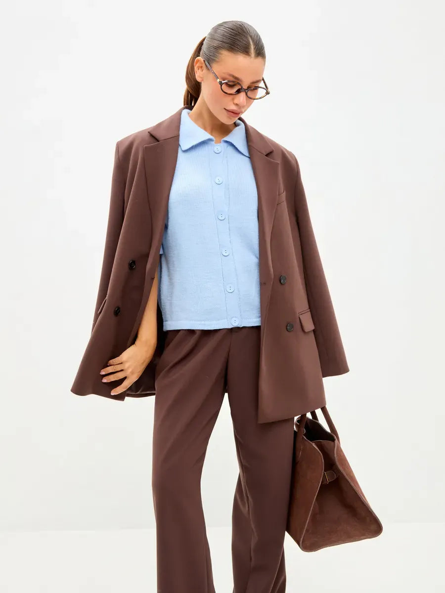 Model wearing Alba Cardigan in blue under a brown blazer, showcasing stylish knitwear from Lauven.