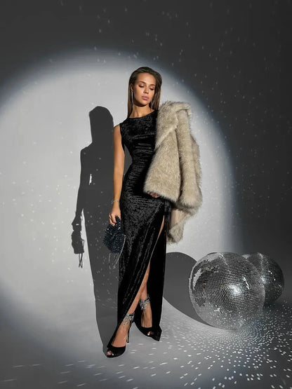 Vespera Maxi Dress by Lauven featuring a velvet silhouette, high-slit detail, and luxurious fur wrap in a glamorous setting.