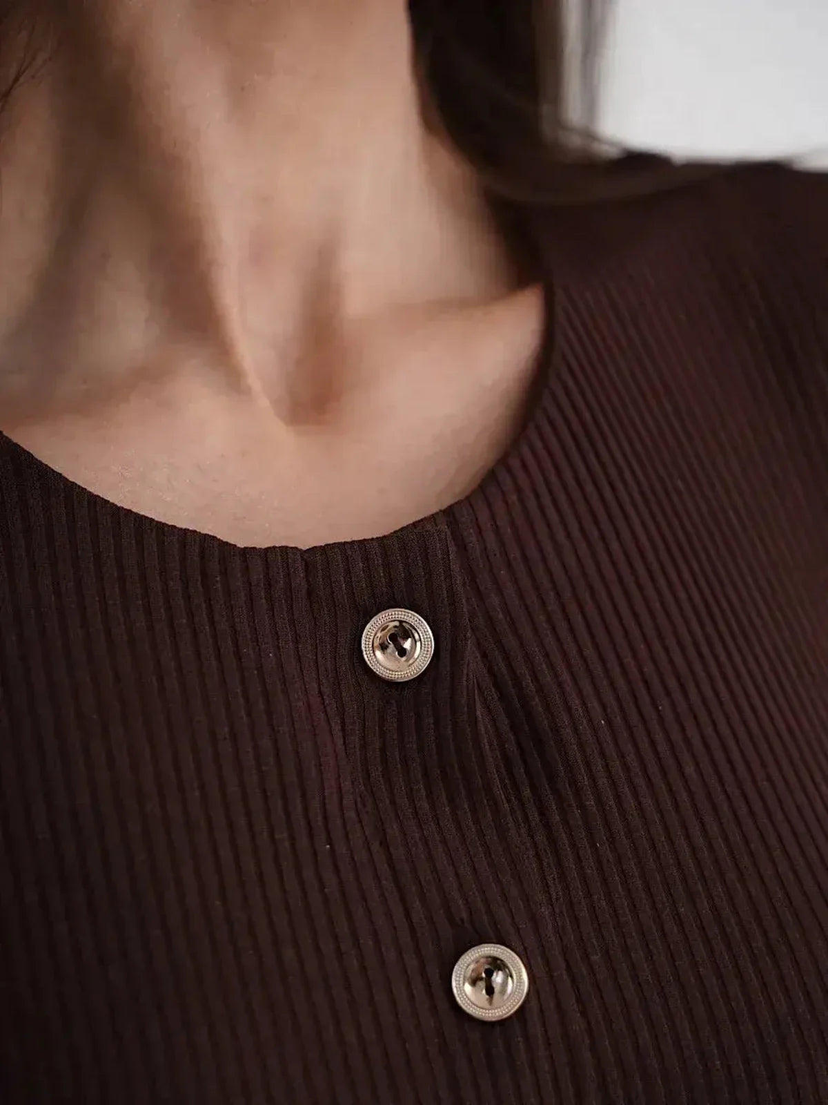 Close-up of Midi Dress Noirette's ribbed texture and decorative button detailing.