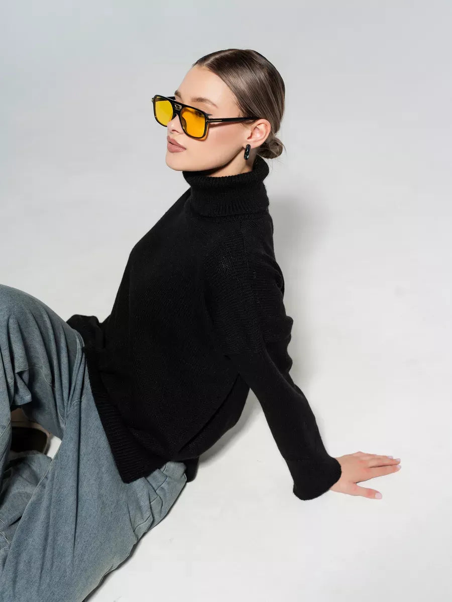 Onyx Sweater by Lauven, an oversized black knitwear piece worn stylishly with gray pants and sunglasses.