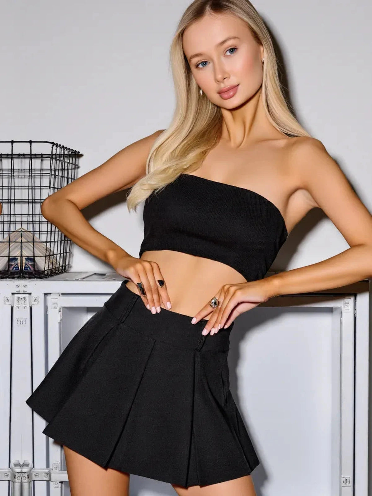 Model wearing Noir Mini Skirt by Lauven, showcasing the black high-waisted pleated skort with built-in shorts.