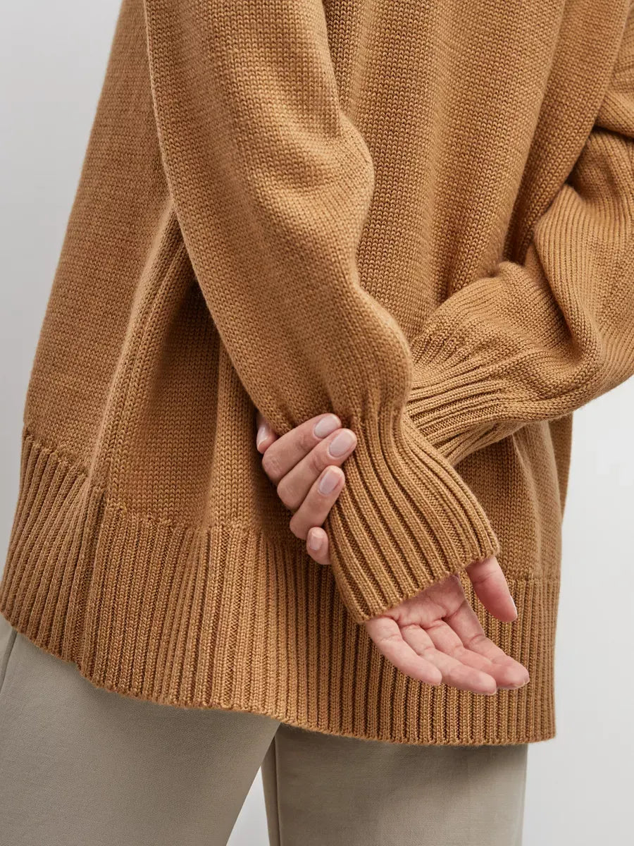 Close-up of Marlo Sweater by Lauven, showcasing its oversized knit design and ribbed cuffs in warm camel color.